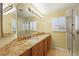 Bathroom featuring granite countertops, dual sinks, and a glass-enclosed shower at 255 El Camino Verde St, Henderson, NV 89074