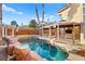 This backyard has a beautiful pool with rock features, shaded pergola and well maintained yard at 255 El Camino Verde St, Henderson, NV 89074