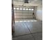 Spacious garage featuring an automatic door with a window panel and concrete flooring at 2694 Hillgrass Rd, Las Vegas, NV 89123