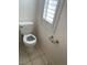 Toilet with decorative seat cover in bathroom with window and white shutters at 2694 Hillgrass Rd, Las Vegas, NV 89123