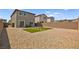 Low-maintenance backyard featuring a rock ground cover, small patch of grass, and a brick paver section at 2724 High Echelon Rd, North Las Vegas, NV 89086