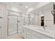 Bathroom featuring double sinks, white cabinetry, and walk-in shower with glass doors at 2724 High Echelon Rd, North Las Vegas, NV 89086