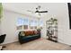 Brightly lit living room showcasing a comfortable couch, large windows, and a decorative plant shelf at 2724 High Echelon Rd, North Las Vegas, NV 89086