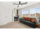 Living room with a green couch, a desk, a large window, and carpeted flooring at 2724 High Echelon Rd, North Las Vegas, NV 89086