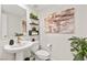 Stylish powder room with a pedestal sink, decorative shelves, and an artistic accent wall at 2724 High Echelon Rd, North Las Vegas, NV 89086