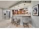 Charming bar area features dark cabinets, granite countertops, and seating for three at 30 Via Mantova # 202, Henderson, NV 89011