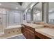 Contemporary bathroom featuring dual sinks, marble countertops, and a glass enclosed shower at 30 Via Mantova # 202, Henderson, NV 89011