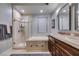 Bathroom featuring double sinks, soaking tub, and a glass-enclosed shower with marble tile at 30 Via Mantova # 202, Henderson, NV 89011