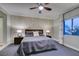 Neutral bedroom with large window, ceiling fan, and lamps on either side of bed at 30 Via Mantova # 202, Henderson, NV 89011