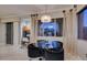 Bright dining area featuring a glass table, contemporary lighting, and views of the terrace through sheer-paneled windows at 30 Via Mantova # 202, Henderson, NV 89011