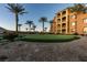 Beautiful apartment complex exterior with lush landscaping and mature palm trees at 30 Via Mantova # 202, Henderson, NV 89011