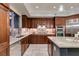 Well-equipped kitchen featuring stainless steel appliances, dark wood cabinets, and a granite island at 30 Via Mantova # 202, Henderson, NV 89011