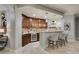 Beautiful wet bar featuring dark wood cabinetry, stone countertops and travertine floors at 30 Via Mantova # 202, Henderson, NV 89011