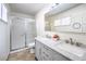 Bright bathroom with dual sink vanity, framed mirror, and glass enclosed shower at 3163 High View Dr, Henderson, NV 89014