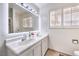 Bright bathroom with double sinks, illuminated mirror, and modern fixtures at 3163 High View Dr, Henderson, NV 89014