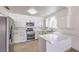 Modern white kitchen with stainless steel appliances and bar seating at 3163 High View Dr, Henderson, NV 89014