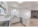 Bright kitchen features white cabinetry, stainless appliances, and stone fireplace in the adjacent living area at 3163 High View Dr, Henderson, NV 89014