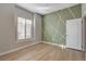 Stylish bedroom featuring a decorative accent wall, plantation shutters, and modern flooring at 3360 Cactus Shadow St # 102, Las Vegas, NV 89129