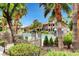 Community swimming pool surrounded by lush landscaping and palm trees on a bright sunny day at 3360 Cactus Shadow St # 102, Las Vegas, NV 89129