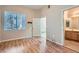 Bedroom featuring wood laminate flooring with a bathroom view and natural light at 3451 Desert Cliff St # 103, Las Vegas, NV 89129