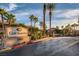 View of the Cliff Shadows community entrance featuring a stone sign, palm trees, and well-maintained landscaping at 3451 Desert Cliff St # 103, Las Vegas, NV 89129