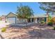 Inviting front yard with desert landscaping, mature trees, and a charming single-story home with a two-car garage at 3730 Greenwood Dr, Las Vegas, NV 89103