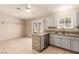 Kitchen with tile flooring, stainless steel dishwasher, grey cabinets, and a breakfast bar at 3730 Greenwood Dr, Las Vegas, NV 89103