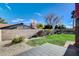 A private backyard features a small lawn area, gravel beds, and a tiled patio at 3998 Foxgrove Dr, Las Vegas, NV 89147