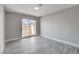 Spacious bedroom with grey laminate floors and sliding glass door to the outside at 3998 Foxgrove Dr, Las Vegas, NV 89147