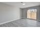 A bright bedroom features grey wood-look flooring and a sliding glass door to the outside at 3998 Foxgrove Dr, Las Vegas, NV 89147