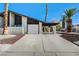 Contemporary house with attached garage, carport and desert landscaping with red and white rock at 3998 Foxgrove Dr, Las Vegas, NV 89147