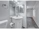 Bright bathroom with a white vanity, toilet, mirror, and sink with updated fixtures at 402 Bell Ave, Henderson, NV 89015