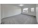 Bright living room featuring neutral walls, gray carpeting, and a large window at 402 Bell Ave, Henderson, NV 89015