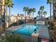 Community pool surrounded by palm trees and well-maintained landscaping at 4228 Hickman Ct, Las Vegas, NV 89129