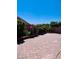 Interlocked brick-paved backyard with garden beds filled with bushes, flowers, and greenery at 4562 White Cap Mill St, Las Vegas, NV 89147