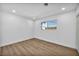 Bedroom showcasing luxury vinyl plank flooring, white walls, and a window at 4629 Lilliput Ln, Las Vegas, NV 89102