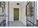 Inviting front porch featuring an ornate metal gate and a stylish olive-green front door at 4629 Lilliput Ln, Las Vegas, NV 89102