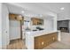 Open kitchen featuring a breakfast bar, wood cabinetry, stainless steel appliances, and a seamless flow to the living area at 4629 Lilliput Ln, Las Vegas, NV 89102