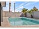 Backyard pool area featuring a refreshing pool, palm trees, and a privacy wall at 4629 Lilliput Ln, Las Vegas, NV 89102