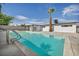 Inviting backyard pool area for swimming, with lush palm trees and landscaping against a clear sky at 4629 Lilliput Ln, Las Vegas, NV 89102