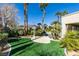 Beautiful backyard featuring lush landscaping, artificial turf, mature trees, and serene outdoor space at 4635 Bird View Ct, Las Vegas, NV 89129