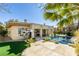 The backyard features a pool with rock waterfall feature and an artificial lawn at 4635 Bird View Ct, Las Vegas, NV 89129