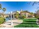 The rear of the home features a large backyard, artificial turf, and a sparkling pool with stone accents at 4635 Bird View Ct, Las Vegas, NV 89129