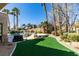 The artificial grass backyard boasts a built-in pool with a rock waterfall feature at 4635 Bird View Ct, Las Vegas, NV 89129