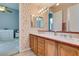 A vanity in the hall bathroom boasts matching sinks, decorative tile counters, and wallpaper at 4635 Bird View Ct, Las Vegas, NV 89129