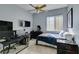 This carpeted bedroom features a ceiling fan, desk with monitors, and a window for plenty of natural light at 4635 Bird View Ct, Las Vegas, NV 89129