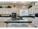 Bright kitchen with white cabinets, granite countertops, and island with a gas cooktop at 4635 Bird View Ct, Las Vegas, NV 89129