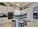 Well-lit kitchen features white cabinets, a center island with seating, and stainless steel appliances at 4635 Bird View Ct, Las Vegas, NV 89129