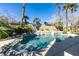 This backyard pool features stone landscaping, a waterfall feature, and mature palm trees at 4635 Bird View Ct, Las Vegas, NV 89129