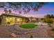 Backyard view showcasing the desert landscaping, artificial turf, and covered patio with outdoor seating at 4718 Atlantico St, Las Vegas, NV 89135